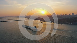 Aerial: Istanbul Bosphorus Bridge at Sunset, large freight ship sailing under