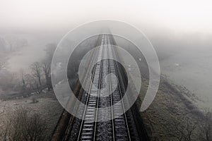 Aerial landscape above railroad tracks on a viaduct on a cold foggy day