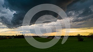 Aerial landscape of countryside with colorful storm clouds. Extreme thunderstorm over a farm and agricultural fields and