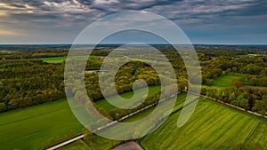 Aerial landscape of countryside with colorful storm clouds. Extreme thunderstorm over a farm and agricultural fields and