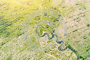Aerial landscape countryside of winding small river, stream in green field, top view meadow