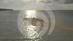 Aerial landscape of lovely travel couple relaxing on the white beach of tropical island in Philippines