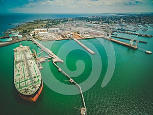 Aerial landscape of oil tanker moored at industrial port. Williamstown, Victoria, Australia.