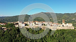 Aerial landscape overlooking a small town located among picturesque mountains and forests. Impressive architecture, Italy