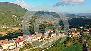 Aerial landscape overlooking a small town located among picturesque mountains and forests. Impressive architecture, Italy