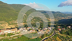 Aerial landscape overlooking a small town located among picturesque mountains and forests. Impressive architecture, Italy