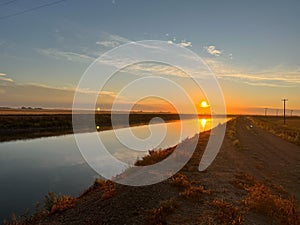 Aerial landscape of a river through a cultivated field at a dreamy sunrise