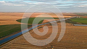 Aerial landscape of a river through a cultivated field at a dreamy sunrise