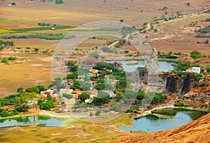 Aerial landscape of small hindu village surrounded by trees, lakes, colorful fields and meadows photo
