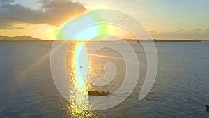 Aerial landscape of tropical coast and flight over the boat at paradise in Candaraman island at sunset.