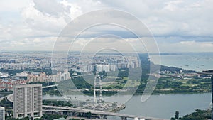 aerial landscape view over marina bay area with giant ferris wheel, singapore housing area and many cruise container ships in the