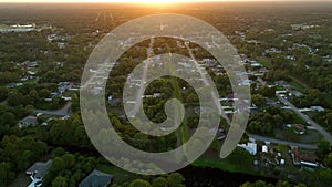 Aerial landscape view of suburban private houses between green palm trees in Florida quiet rural area at sunset