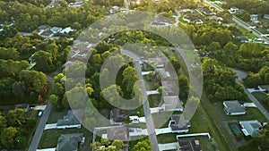 Aerial landscape view of suburban private houses between green palm trees in Florida quiet rural area at sunset