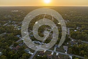 Aerial landscape view of suburban private houses between green palm trees in Florida quiet rural area at sunset