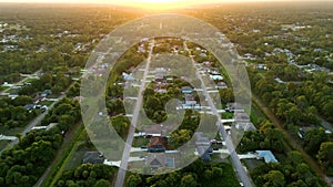 Aerial landscape view of suburban private houses between green palm trees in Florida quiet rural area at sunset