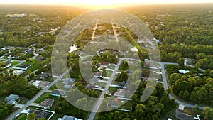 Aerial landscape view of suburban private houses between green palm trees in Florida quiet rural area at sunset