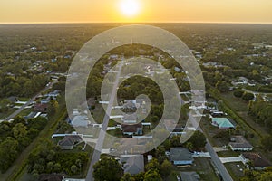 Aerial landscape view of suburban private houses between green palm trees in Florida quiet rural area at sunset