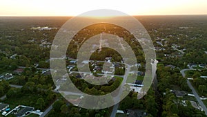 Aerial landscape view of suburban private houses between green palm trees in Florida quiet rural area at sunset