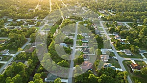 Aerial landscape view of suburban private houses between green palm trees in Florida quiet rural area at sunset