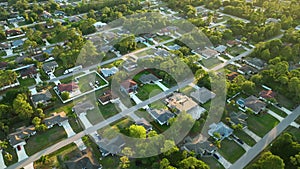 Aerial landscape view of suburban private houses between green palm trees in Florida quiet rural area at sunset