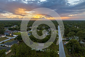 Aerial landscape view of suburban private houses between green palm trees in Florida quiet rural area at sunset