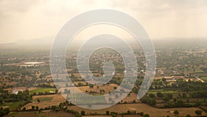 Aerial landscape view of town farms, fields, ground from top of mountain in India. Top view of indian rural village city.