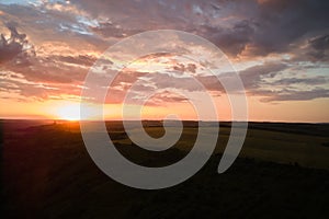 Aerial landscape view of yellow cultivated agricultural field with ripe wheat on vibrant summer evening