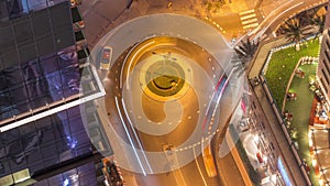 Aerial view of a road intersection between skyscrapers in Dubai marina night timelapse.