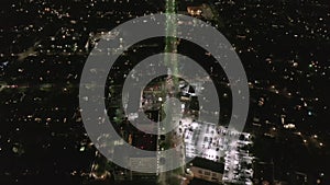 AERIAL: Lookup over Wilshire Boulevard Street in Hollywood Los Angeles at Night with View on Downtown and Glowing