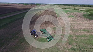 Aerial - Loosening and aerating top layers of soil with a tractor