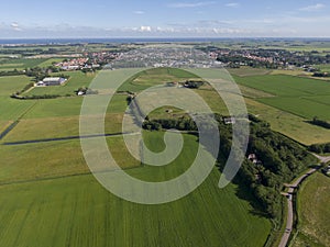Aerial of meadowland with curving road and farms on the dutch island of Texel