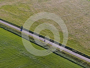 Aerial of meadowland separated by straight bicycle lane with cyclist on the dutch island of Texel photo