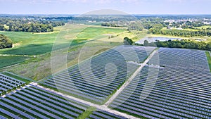 Aerial Midwest solar farm with solar panels in rural area near farmland and swamp