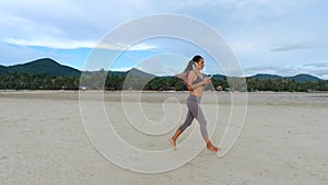 Aerial: Mixed Race Girl Runner Jogging on Beautiful Sandy Beach. Koh Phangan, Thailand. HD Slowmotion.