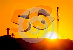 Aerial of mobile communication on a background of a bright sunset. Sihoulette of High antenna. Sun rays and glare. The inscription