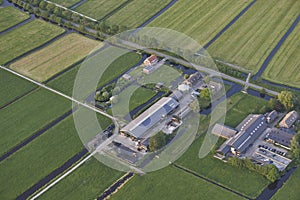 Aerial of modern farms with solar panels on the roof in dutch meadow landscape