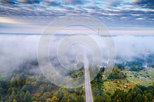 Aerial morning dawn landscape of mist over forest and road