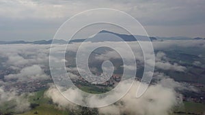 Aerial morning mountains view in the fog in the Low Tatras with city on background