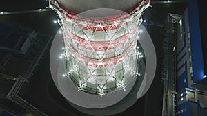 Aerial motion along cooling tower with steam and dark city