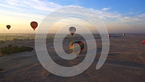 Aerial motion video riding hot air balloon over Luxor Egypt valley of the king Unesco heritage site sunrise