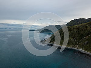 Aerial, Mountain Coastline With Storms On Horizon