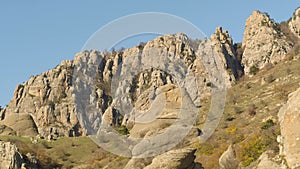 Aerial for mountain ridge with trees in the sunny morning with clear blue sky. Shot. Amazing cliffs with withered grass