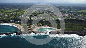 Aerial Moving Into Secluded Beach Shaped By Unique Rock Formation