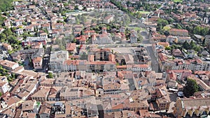 Aerial moving view of small cosy italian city in province, camera is flying over roofs of old buildings