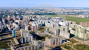 Aerial of new modern city district with many high rise buildings surrounded by green lawn. Motion. Architecture concept
