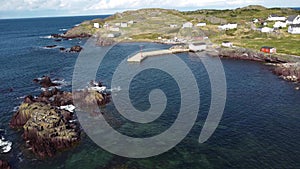 Aerial Newfoundland at a small fishing village with rocky shores and docks