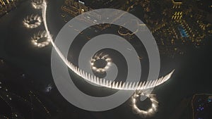 Aerial night shot of the choreographed water fountain in Dubai. At the foot of Burj Khalifa