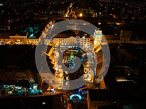 Aerial night shot of city during Christmas, winter and christmas decorations on square. Chistmas market during holiday