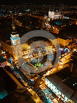 Aerial night shot of city during Christmas, winter and christmas decorations on square. Chistmas market during holiday