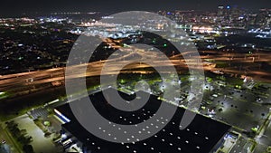 Aerial night view of place for vehicles in front of IKEA mall in Tampa. Many cars parked on parking lot with lines and